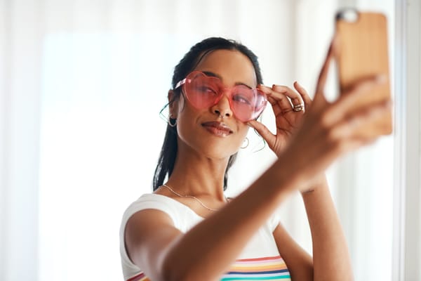 Mulher negra segurando celular